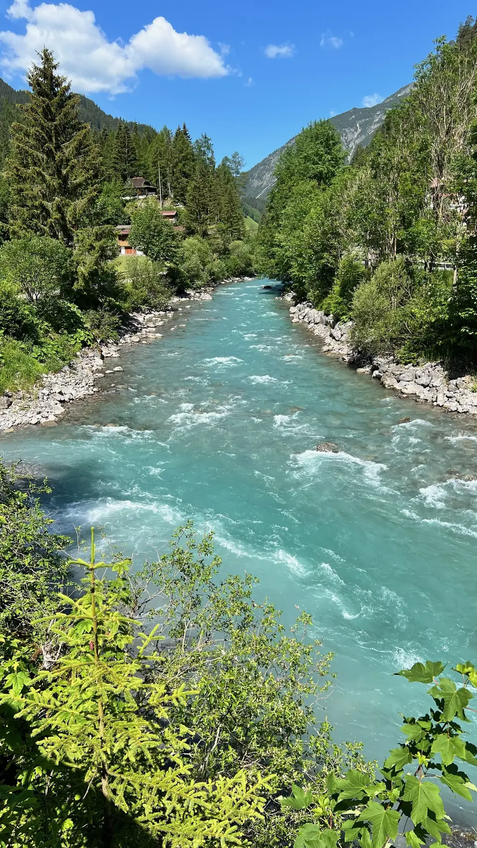 Türkisfarbener Fluss zwischen bewaldeten Ufern